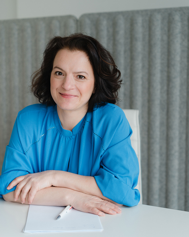 Sandra Brestrich, Marketing-Mentorin, sitzt an einem Schreibtisch. Sie scheint im Gespräch mit einem Kunden.